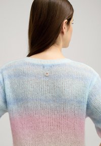 Lekki, dzianinowy sweter z gradientem w pastelowych odcieniach niebieskiego do różowego, z okrągłym dekoltem i małym logo z tyłu.