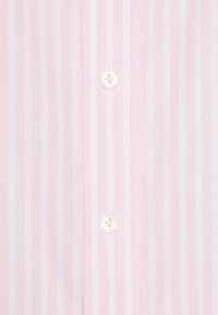 Cămașă cu dungi roz deschis și albe, având o panglică cu nasturi rotunzi cu patru găuri și detalii cusute de-a lungul centrului.