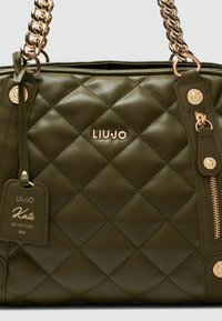 Borsa a tracolla trapuntata verde oliva con hardware dorato, dotata di una tracolla a catena, logo del brand e tasche con zip. Include un'etichetta rimovibile.