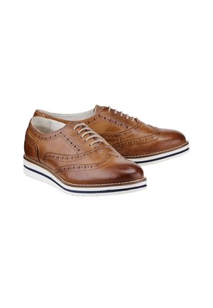 Jasnobrązowe skórzane buty brogue z perforowanymi detalami, białym wiązaniem na sznurówki oraz białą gumową podeszwą z czarnym paskiem.