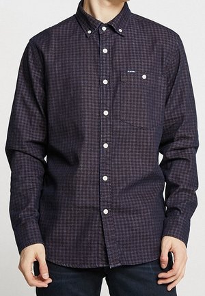 Camisa de manga larga a cuadros en azul marino y burdeos con pequeño bolsillo en el pecho y cuello abotonado, fabricada con una tela texturizada.