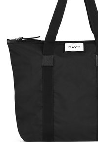 Svart tote-väska tillverkad av hållbar nylon med två robusta tyghandtag, som har ett dragkedjeslut och en rektangulär etikett med "DAY ET."