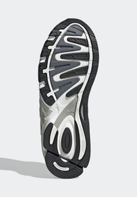 Shoe sole with a black rubber exterior and grey accents. Features a wave pattern and cushioning segments for support. Textured surface for grip.