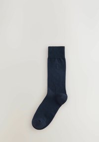 Calzino blu navy con bordo a costine e texture liscia. Senza motivi visibili; presenta un piccolo logo sul lato.