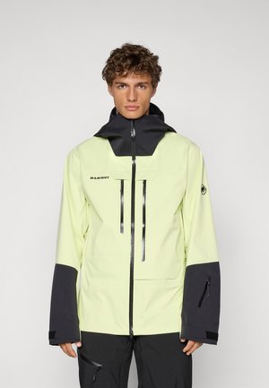 Veste imperméable jaune vif avec un col haut, des accents noirs, deux poches zippées à l'avant et des poignets élastiques. Logo de la marque visible sur la poitrine.