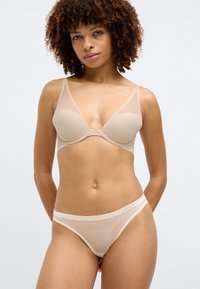 Διαφανές μπουστάκι χωρίς επένδυση και ταιριαστό στρινγκ με λεία cups, ρυθμιζόμενες τιράντες και λογότυπο Calvin Klein κατά μήκος της ζώνης.