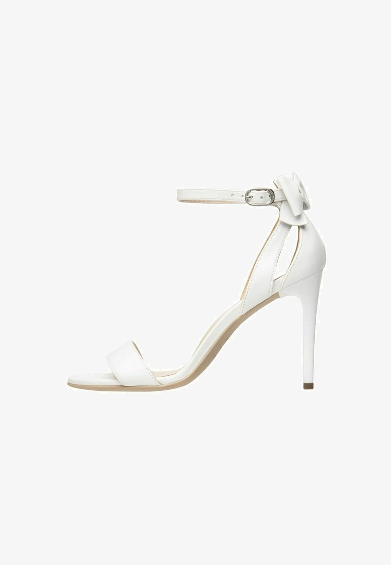 White leather high-heeled sandals with a narrow ankle strap, low front band, and a decorative bow detail at the heel.