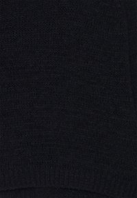 Svart stickad mössa med ribbat brätte. Mjuk textur och medelhårdhet, utformad för värme och komfort. Enkel och mångsidig look.