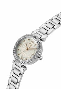 Orologio in acciaio inossidabile argentato con cassa rotonda, quadrante in madreperla bianca, numeri romani e una lunetta intrecciata. Presenta un bracciale a maglie.