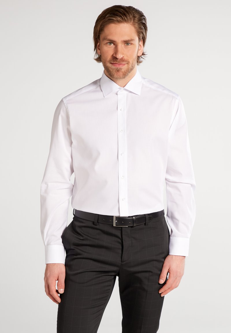 Weißes Langarmhemd mit klassischem Kragen und Knopfleiste, kombiniert mit schwarzer karierten Hose, die über eine glatte Textur und einen maßgeschneiderten Schnitt verfügt.