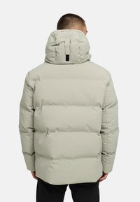 Šviesiai pilkas paminkštintas džemperis su aukštu apykakle, turintis gobtuvą ir juodą dirželio detalę nugaroje. Medžiaga atrodo lygi ir izoliuota.