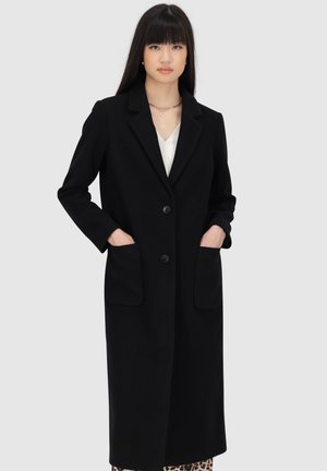 Schwarzer langer Mantel mit taillierter Silhouette, Reverskragen, zwei frontalen Taschen und zwei Knöpfen. Glattes Gewebe mit leichtem Struktur.