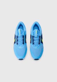 Blå och marinblå sportskor med mesh-övre, snörning, ljusblå detaljer och en gul Nike-logga på tungan och sidan.