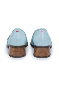 Scarpe in pelle azzurro chiaro con un tacco in legno basso e arrotondato, caratterizzate da un accento dorato e un piccolo dettaglio rosso alla base del tacco.