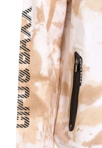 Tie-dye sweatshirt in beige and off-white, featuring a vertical black graphic on the sleeve and a black zippered pocket with branding.
