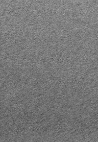 Tessuto grigio con una superficie liscia, caratterizzato da un delicato motivo a maglia uniforme. Nessun motivo o accento distintivo visibile.