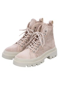 Botas de tobillo de ante beige con paneles perforados, puntera redonda, suelas de goma blanca gruesa y cordones en la parte delantera con ojales plateados.
