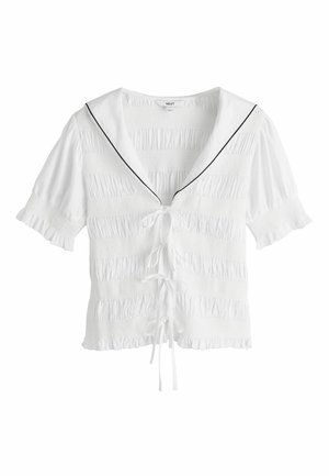 Biała bluzka z krótkim rękawem o marszczonej teksturze, kołnierz marynarski z czarnym wykończeniem, zapięcia z przodu na wiązanie oraz falbanki na rękawach i dole.