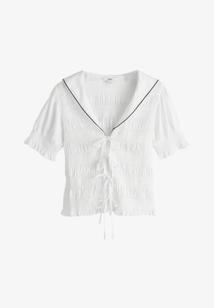 Fehér rövid ujjú blúz ráncolt textúrával, fekete szegéllyel díszített tengerészkarral, elején megkötőkkel és fodros szegéllyel az ujjakon és az alsó részen.