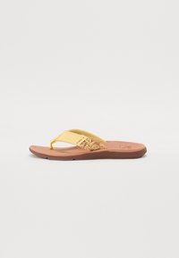 Sandale flip-flop galbene cu un model floral decorativ pe curea, talpă moale texturată și talpă din cauciuc maro. Post de deget ajustabil.