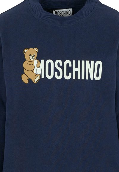 Felpa blu navy con grafica di un orso cartone animato e testo "MOSCHINO" in bianco. Realizzata in morbido tessuto con colletto girocollo e polsini a costine.
