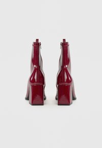 Patent burgundiški auliniai batai su kvadratiniu kulnu ir užtrauktuku gale, pasižymintys elegantišku dizainu ir sklandžia tekstūra.