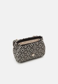 Black and white woven handbag with diamond pattern, small flap with gold snap closure, and interior lining printed with brand name.