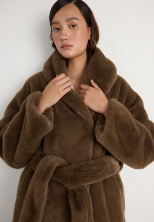 Rjava umetna krzna halja s širokim ovratnikom, pasom in velikimi rokavi, ki se ponaša z mehko, puhasto teksturo po vsej površini.