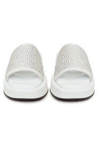 Sandales slides blanches avec semelles rembourrées et larges brides couvertes de petits strass argentés, vues de face.