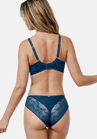 Soutien-gorge en dentelle bleu marine et culotte assortie, avec des motifs floraux décoratifs, des bretelles ajustables et une finition douce et texturée.