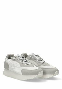 Zapatillas grises y blancas con una mezcla de texturas suave y de ante. Presentan un diseño ligero, puntera redondeada y acentos texturizados en la parte superior.