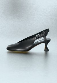 Μαύρο δερμάτινο παπούτσι slingback με τετράγωνη μύτη, ρυθμιζόμενο λουράκι με αγκράφα και μοναδική φουσκωτή μεσαίου ύψους σόλα.