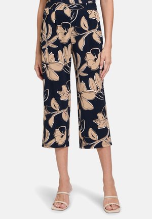 Navy blue cropped pants with a beige floral pattern; made of lightweight fabric, featuring a relaxed fit and pockets.