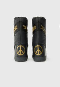 Fekete magas szárú csizmák nylon felsőrésszel, arany "LOVE MOSCHINO" felirattal és békejel akcentussal a sarkon. Texturált talp a tapadásért.