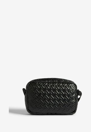 Čierny tkaný kozmetický vak s obdĺžnikovým tvarom, lesklou textúrou a jemným vzorom. Má dvojité postranné úchyty pre jednoduché prenášanie.