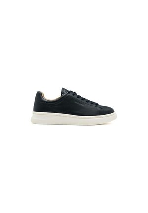 Zapatilla de cuero negra con textura suave, suela de goma blanca, punta redonda y ojales de metal para los cordones. Diseño minimalista.