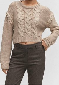 Beige gebreide cropped trui met vlechttextuur, lange mouwen en een brede halslijn, gecombineerd met grijze geruite tailor-made broek.