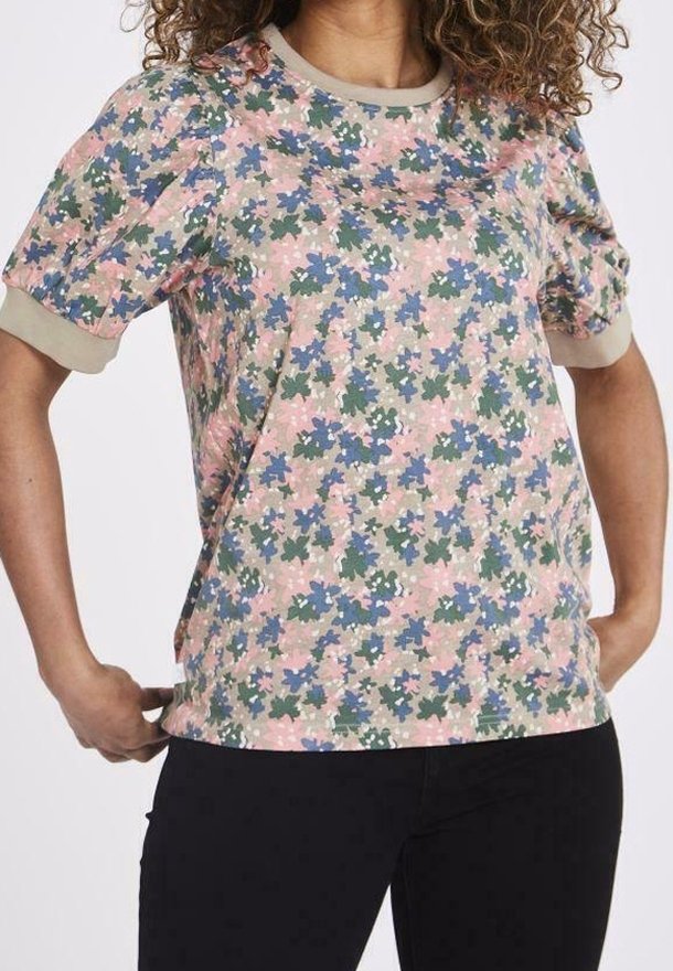 Top de manga corta con estampado floral en varios colores, incluyendo rosa, verde y azul, con un cuello y dobladillo en color beige. Textura de tela suave.