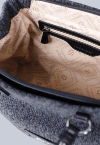 Borsa in tessuto grigio, con texture, e una tasca interna nera liscia. Foderata con un motivo beige che presenta il logo "CAFÉ NOIR" in tutta la superficie.