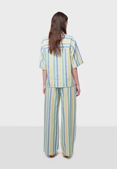 Gestreepte katoenen outfit in pasteltinten van blauw, geel en groen. Heeft een losse korte mouwen top en brede broekspijpen.