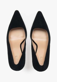 Černé suède lodičky s špičatou špičkou a výřezem na stranách, s hladkým béžovým vnitřním podšíváním a jemně embosovaným logem.