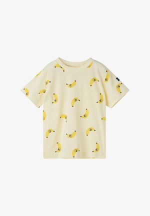 Børne-T-shirt med korte ærmer i cremefarve med et mønster af smilende gule bananer spredt over stoffet.