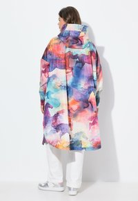 Farverig lang frakke i let stof med et akvareldesign, der viser løbende heste i nuancer af pink, blå og lilla. Med hætte.