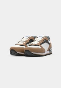 Sneakers met een combinatie van bruine suede, witte leren en grijze mesh, met een zwarte rubberen zool en vetersluiting. Merkbewerking op de tong.