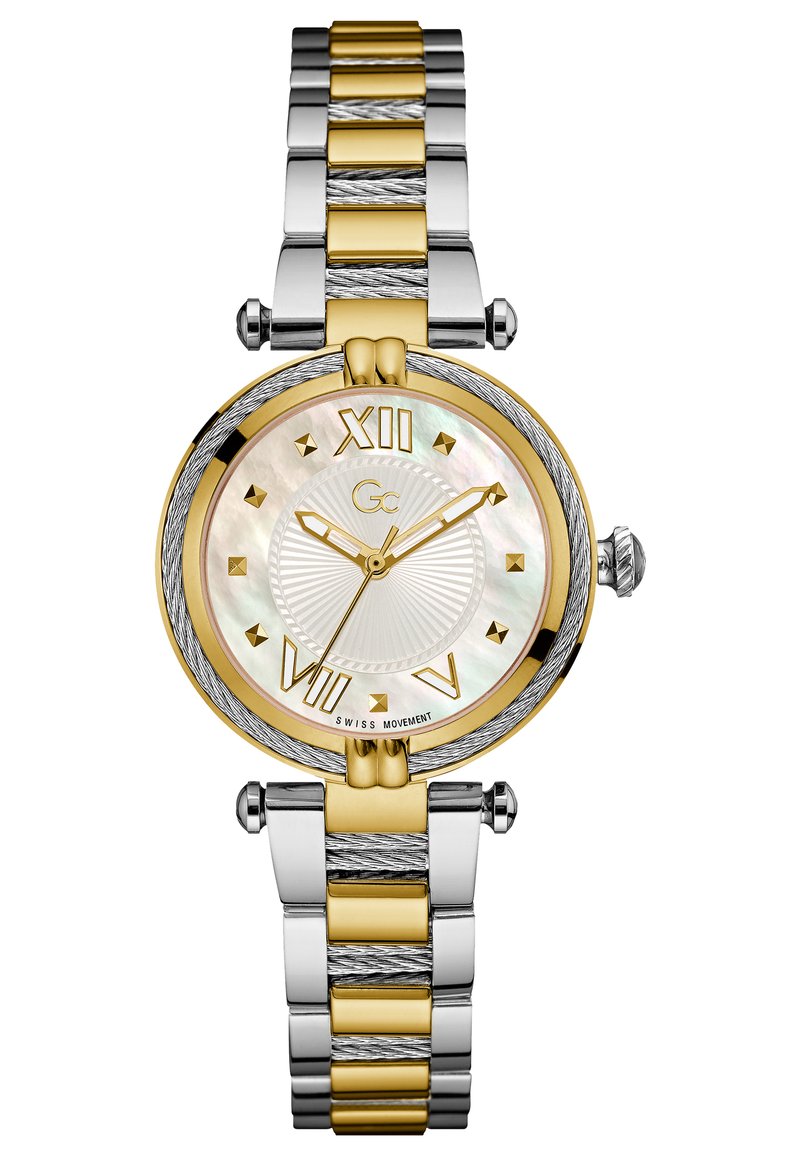 Ura z zlatim in srebrnim tonom z okroglo številčnico iz matere perle, označeno z rimskimi številkami, in strukturiranim dvotonskim kovinskim naramkom.