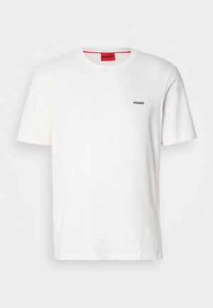 T-shirt en coton blanc avec col ras du cou, manches courtes, présentant un petit logo noir "HUGO" sur le côté gauche de la poitrine et une étiquette rouge contrastante à l'intérieur.