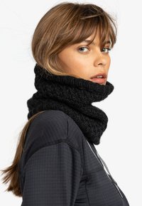 Svart stickad cowl-nick, med ett texturerat mönster. Designen är tjock och mysig, och omsluter halsen tätt.