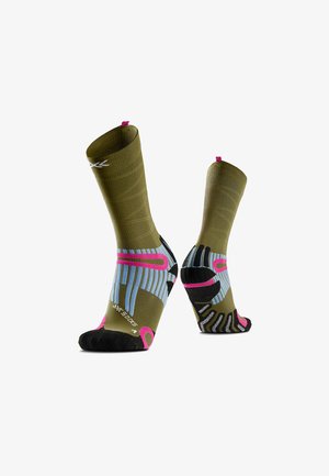 Paire de chaussettes de sport vert olive avec semelles noires, accents roses et bleus, et texture côtelée, présentées debout sur fond blanc.