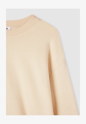 Jasno beżowy, oversize'owy sweatshirt z karbowanym okrągłym dekoltem i opuszczonymi ramionami, wykonany z miękkiej, strukturalnej tkaniny.