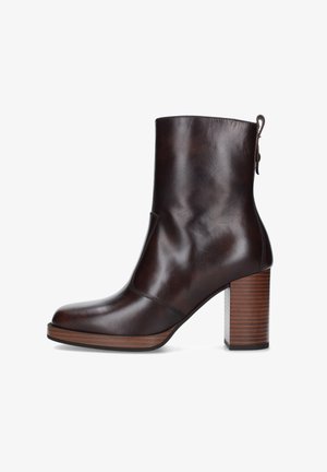 Stivaletto alla caviglia in pelle marrone scuro con tacco a blocco in legno impilato e punta arrotondata, dotato di un laccetto sul retro.